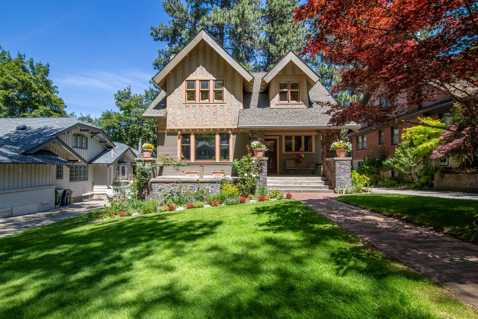 A home with a manicured green lawn and landscaped flower beds